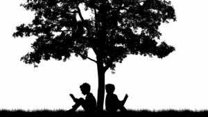 children sitting under a tree reading books