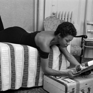 Dr. Maya Angelou laying on bed reading a magazine